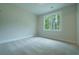 Empty bedroom with neutral carpet and a window overlooking a backyard filled with trees at 1709 Eastside Parc St, Atlanta, GA 30316