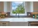 Modern kitchen sink with white cabinets, gray backsplash, and a view of the greenery, creating a clean and functional area at 1709 Eastside Parc St, Atlanta, GA 30316