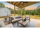 Relaxing covered back patio showcasing an outdoor seating area with ceiling fan overlooking private wooded backyard at 1709 Eastside Parc St, Atlanta, GA 30316