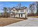 Beautiful two story home with white siding, metal roof, landscaped front yard, and concrete driveway at 1697 Eastside Parc St, Atlanta, GA 30316