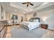 Bright main bedroom featuring a ceiling fan, tray ceilings, seating area, and stylish accents, enhancing comfort at 1697 Eastside Parc St, Atlanta, GA 30316