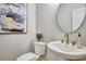 Stylish powder room with a modern vanity, round mirror, and elegant fixtures, complemented by tasteful decor at 1697 Eastside Parc St, Atlanta, GA 30316