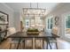 Bright dining room featuring a dark wood table, a modern chandelier, and views into the open-concept kitchen at 1702 Eastside Parc St, Atlanta, GA 30316