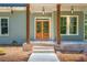 Inviting front porch featuring wooden pillars, double doors, and classic pendant lighting at 1702 Eastside Parc St, Atlanta, GA 30316