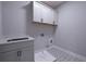Well-lit laundry room with stylish tile flooring, basin sink, and ample cabinetry at 1702 Eastside Parc St, Atlanta, GA 30316
