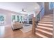 Bright and airy living room featuring a fireplace, large windows, and elegant staircase with wood and metal railing at 1702 Eastside Parc St, Atlanta, GA 30316