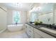 Spa-like main bathroom featuring a freestanding tub, dual vanities, and a separate glass-enclosed shower at 1702 Eastside Parc St, Atlanta, GA 30316