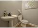 Well-lit powder room with pedestal sink, toilet, and stylish decor at 1702 Eastside Parc St, Atlanta, GA 30316