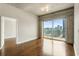 Bright living room with hardwood floors, access to a balcony with city views, and an open doorway at 361 17Th Nw St # 1001, Atlanta, GA 30363