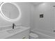 Stylish bathroom with a sleek vanity, circular lighted mirror, and a tiled shower at 159 Shadburn Ferry Rd, Buford, GA 30518