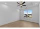 Bright bedroom with hardwood floors, large windows offering neighborhood views, and a modern ceiling fan at 159 Shadburn Ferry Rd, Buford, GA 30518
