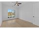Well-lit bedroom with hardwood floors, ceiling fan, and large window with neighborhood view at 159 Shadburn Ferry Rd, Buford, GA 30518