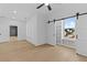 Bedroom with hardwood floors, white trim, barn door and a view of the outdoors at 159 Shadburn Ferry Rd, Buford, GA 30518