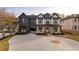 Charming two-story home featuring a black and white exterior, complemented by an expansive driveway and manicured landscaping at 159 Shadburn Ferry Rd, Buford, GA 30518