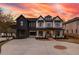 Beautiful two-story home featuring a black and white exterior, complemented by an expansive driveway and manicured landscaping at 159 Shadburn Ferry Rd, Buford, GA 30518
