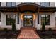 Inviting entryway with a brick walkway, stone columns, and a modern glass door, enhanced by stylish lighting at 159 Shadburn Ferry Rd, Buford, GA 30518