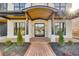 Inviting entryway with a brick walkway, stone columns, and a modern glass door, enhanced by stylish lighting at 159 Shadburn Ferry Rd, Buford, GA 30518