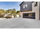 Modern house with a spacious driveway leading to a sleek black garage, complemented by stylish exterior lighting at 159 Shadburn Ferry Rd, Buford, GA 30518