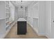 Spacious walk-in closet with custom shelving, center island, and elegant lighting at 159 Shadburn Ferry Rd, Buford, GA 30518