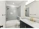 Modern bathroom featuring a white bathtub, gray tile walls, vanity, sink and mirror at 2611 Charlesgate Ave, Decatur, GA 30030
