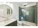 Modern bathroom featuring a glass shower with green tile, vanity with round mirror and stylish floor at 2611 Charlesgate Ave, Decatur, GA 30030