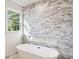 Modern bathroom featuring a soaking tub, and stone wall feature at 2611 Charlesgate Ave, Decatur, GA 30030