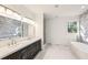 A modern bathroom featuring double sinks, sleek lighting, and a separate tub and shower at 2611 Charlesgate Ave, Decatur, GA 30030