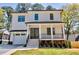Charming two-story home with a white exterior, covered porch, landscaped yard, and attached garage at 2611 Charlesgate Ave, Decatur, GA 30030
