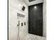 Beautiful walk-in shower featuring black herringbone tile, rainfall shower head, and gray pebble floor at 2611 Charlesgate Ave, Decatur, GA 30030