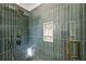 Stylish tiled shower with green vertical tiles, gold fixtures, a shower niche and a mosaic tiled shower floor at 2611 Charlesgate Ave, Decatur, GA 30030