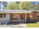 Charming brick home with red shutters, a cozy front porch, and well-maintained landscaping at 2420 Green Rd, Loganville, GA 30052