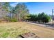 A spacious front yard with mature trees, a garden bed, and a view of the quiet neighborhood street at 2420 Green Rd, Loganville, GA 30052