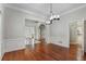 Open dining room featuring hardwood floors, crown molding, contemporary chandelier, and white wainscoting at 940 Waters Reach Ct, Alpharetta, GA 30022