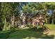 Charming brick home with a landscaped front yard nestled amongst mature trees in a quiet neighborhood at 940 Waters Reach Ct, Alpharetta, GA 30022
