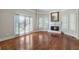 Sunlit living room featuring hardwood floors, a cozy fireplace, and large windows with a backyard view at 940 Waters Reach Ct, Alpharetta, GA 30022