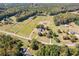 Aerial view of a home, outbuildings, and surrounding acreage with wooded borders at 1201 Keencheefoonee Rd, Rutledge, GA 30663