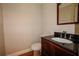 Powder room features a dark vanity and sink with tile flooring at 1201 Keencheefoonee Rd, Rutledge, GA 30663