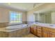 Bright bathroom featuring a soaking tub with tile surround and a double sink vanity at 1201 Keencheefoonee Rd, Rutledge, GA 30663