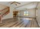 Bright living area with wood floors, staircase, and abundant natural light from large windows at 1201 Keencheefoonee Rd, Rutledge, GA 30663