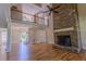 Open-concept living room featuring a stone fireplace, hardwood floors, and upper-level balcony at 1201 Keencheefoonee Rd, Rutledge, GA 30663