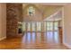 Bright living room with stone fireplace, hardwood floors, and many windows overlooking the yard at 1201 Keencheefoonee Rd, Rutledge, GA 30663