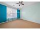 Bedroom with neutral carpet, large windows, ceiling fan and blue accent wall at 400 17Th Nw St # 2120, Atlanta, GA 30363