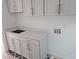 White laundry room with quartz countertop, modern cabinets, and geometric patterned floor tiles at 490 Waterman St, Marietta, GA 30060