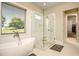 Relaxing bathroom with a freestanding tub, glass-enclosed shower, and a large window for natural light at 255 Old Town Rd, Dacula, GA 30019