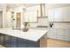 Modern kitchen featuring white cabinets, stainless steel appliances, and a spacious island with dark blue cabinetry at 255 Old Town Rd, Dacula, GA 30019