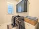Convenient laundry room featuring front loading washer and dryer and ample storage cabinets at 255 Old Town Rd, Dacula, GA 30019