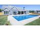 Beautiful backyard pool with patio, seating, and lovely blue siding on the home at 255 Old Town Rd, Dacula, GA 30019