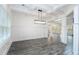 Dining room featuring gray wood floors, white trim and wainscotting, a modern chandelier, and large windows at 1176 Red Oak Blvd, Loganville, GA 30052