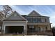 Two story house with neutral colored siding, gray shutters and brick foundation with attached two car garage at 1176 Red Oak Blvd, Loganville, GA 30052