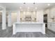 Kitchen island with a white countertop and a stainless steel sink, surrounded by white cabinets and walls at 1176 Red Oak Blvd, Loganville, GA 30052